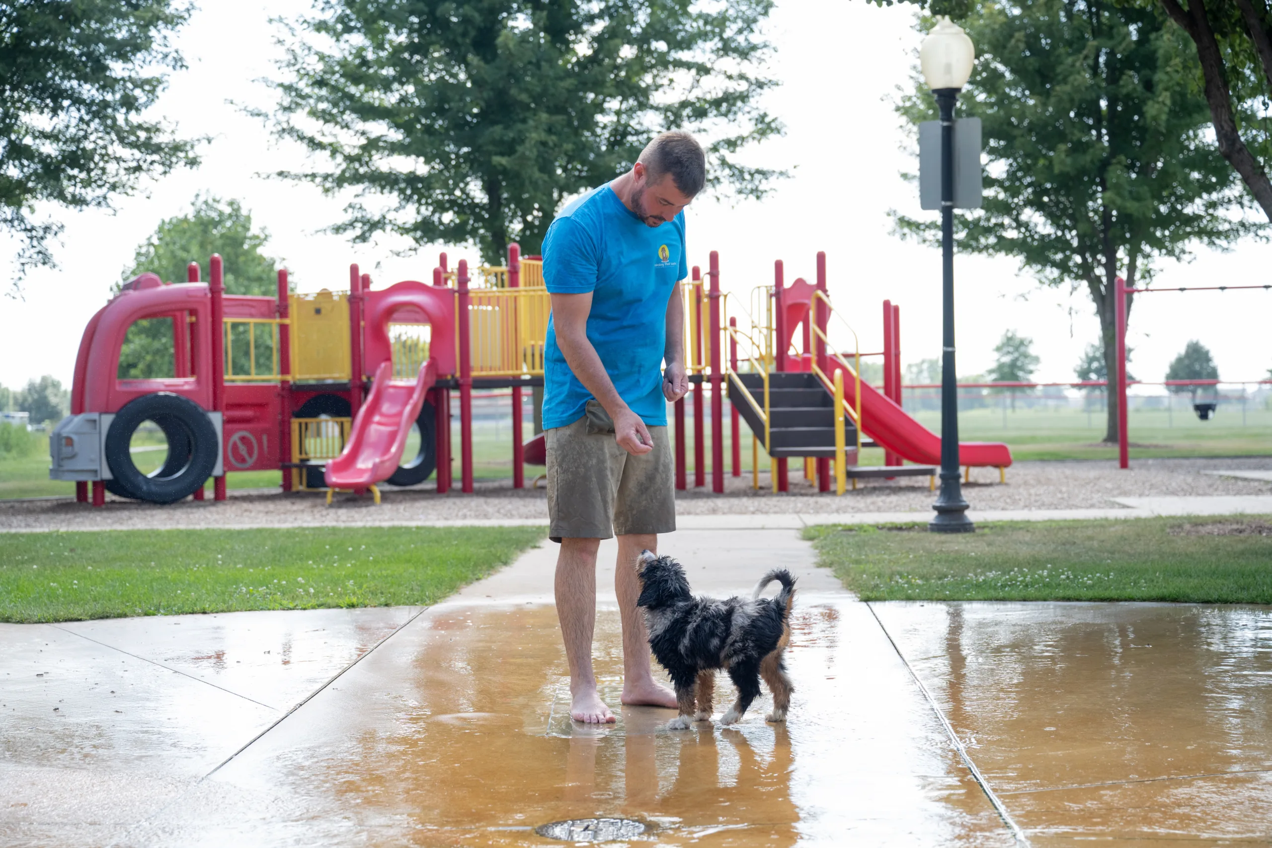 Local Dog Trainer Tyler Morrick playing with a puppy at the water park during training