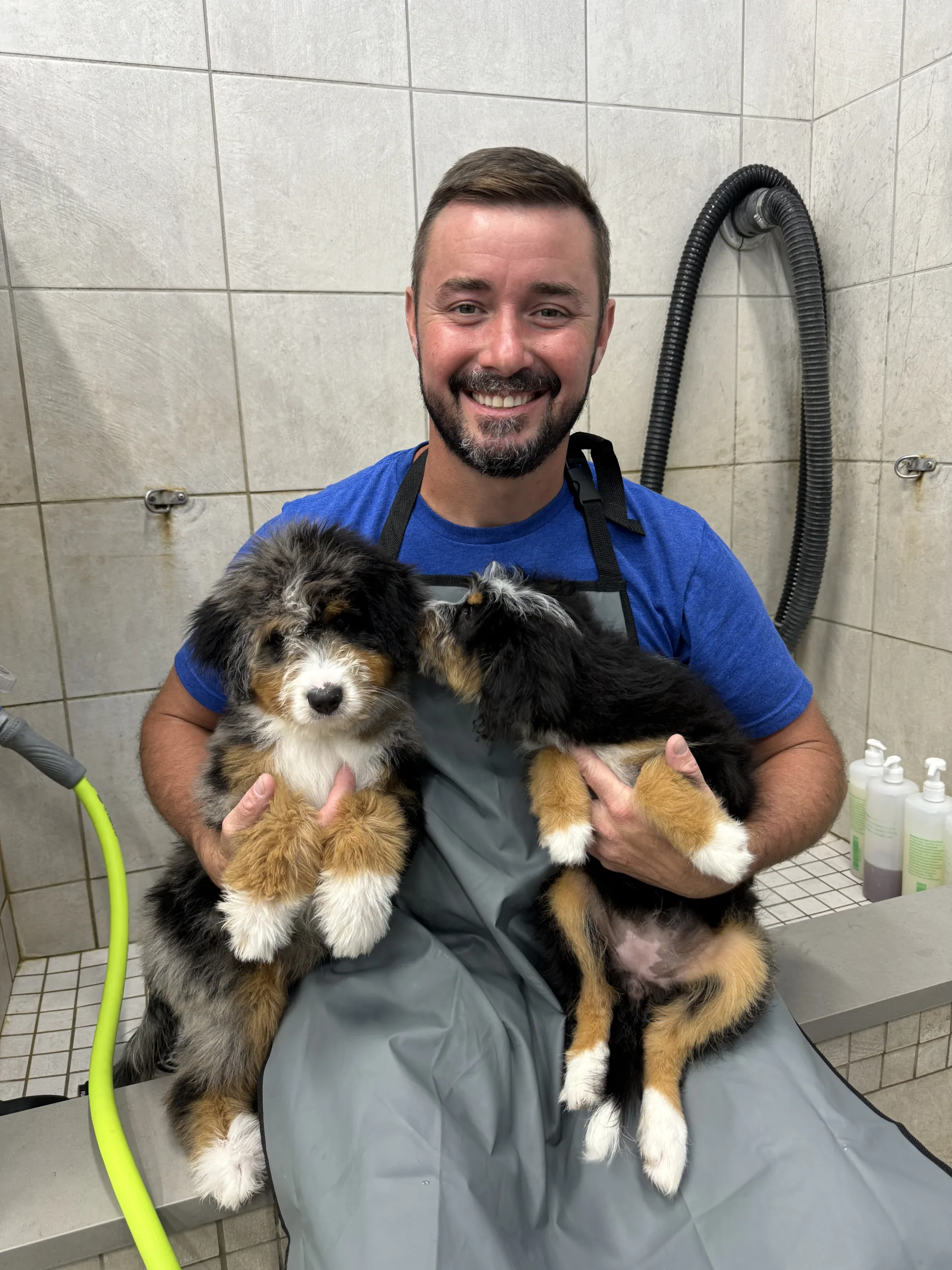 Head Trainer Tyler with puppies and the groomer getting them cleaned up before meeting their forever parents